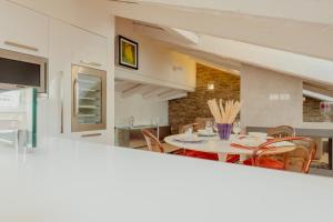uma cozinha e sala de jantar com mesa e cadeiras em Aphrodite Luxury penthouse with Jacuzzi em Trieste
