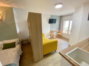 Телевизор и/или развлекательный центр в L'Escale Appartements et Suites en bord de Mer