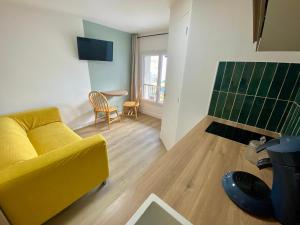 Телевизор и/или развлекательный центр в L'Escale Appartements et Suites en bord de Mer