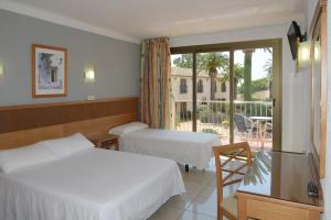 ein Hotelzimmer mit 2 Betten und einem Balkon in der Unterkunft Hotel San Carlos in Roses