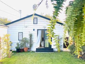 een wit huis met planten ervoor bij Charming 3 BR Home Near SoFi and LAX - 65th in Los Angeles