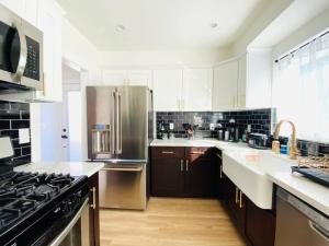 a kitchen with a stainless steel refrigerator and a stove at Charming 3 BR Home Near SoFi and LAX - 65th in Los Angeles