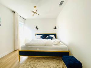 een slaapkamer met een bed in een witte kamer bij Charming 3 BR Home Near SoFi and LAX - 65th in Los Angeles
