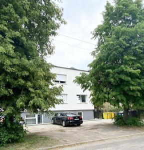 a black car parked in front of a white building at Apartament Goplańska FREE PARKING in Poznań