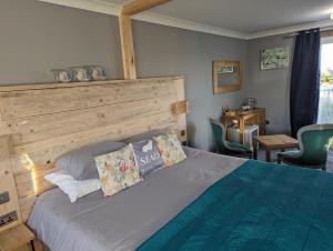 a bedroom with a bed with a wooden headboard at Seals Bacton in Bacton