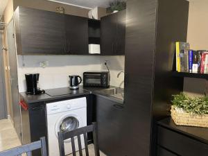 a kitchen with a washing machine and a washer at Charmant T2 rénové avec clim, WiFi et parking à 15 min des Thermes de Balaruc-les-Bains - FR-1-553-229 in Balaruc-les-Bains +2 photos