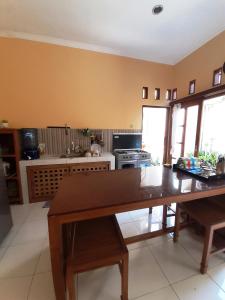 a kitchen with a wooden table in a room at Serasa Rumah Couple in Yogyakarta