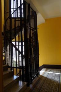 a black spiral staircase in a room with a yellow wall at Charming studio overlooking a beautiful garden in Nice