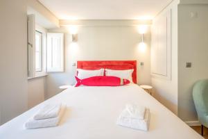 - une chambre avec un grand lit blanc et 2 oreillers rouges dans l'établissement GuestReady - Atalaia Studio 1, à Lisbonne