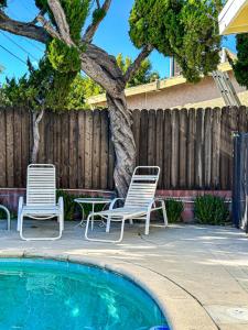 duas cadeiras e uma árvore ao lado de uma piscina em Relaxing 4-BR Oasis with Pool - BB em Los Angeles