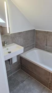 杜伊斯堡的住宿－Deluxe Loftapartement Big Size，浴室配有白色浴缸和水槽