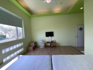 a bedroom with two white beds and a window at Divewhale Homestay in Xiaoliuqiu