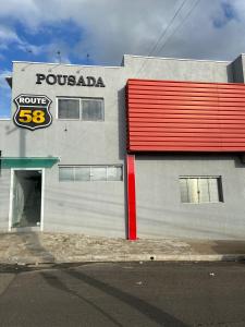 a store with a sign on the side of a building at Pousada Route 58 in Gravataí
