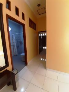 a bathroom with a toilet and a glass door at Serasa Rumah Couple in Yogyakarta