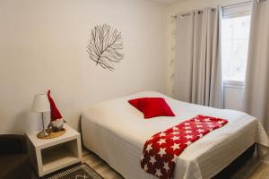 a bedroom with a bed with a red and white blanket at Paritalohuoneisto lähellä Joulupukin Pajakylää in Rovaniemi