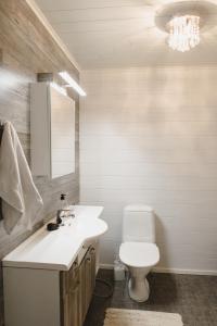 a bathroom with a white sink and a toilet at Paritalohuoneisto lähellä Joulupukin Pajakylää in Rovaniemi