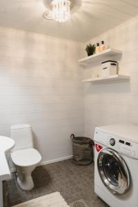 a bathroom with a washing machine and a toilet at Paritalohuoneisto lähellä Joulupukin Pajakylää in Rovaniemi