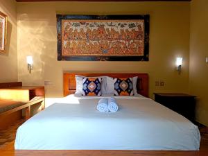 a bedroom with a white bed with two slippers on it at Southern Bali Villa in Nusa Dua