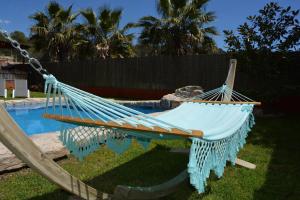 a hammock in a yard next to a pool at Villa Sitges El Olivo High Comodity AC Pool Heated 30º Optional Real Garden Pool XXL 10 min drive from Sitges in Olivella +29 photos