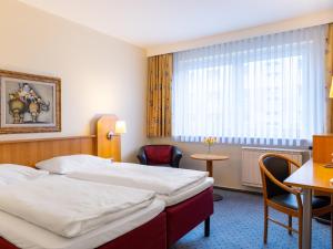 um quarto de hotel com duas camas e uma mesa em Good Morning + Berlin City East em Berlim