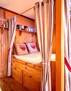 Cette chambre en bois comprend un lit à baldaquin. dans l'établissement Appartement Front de neige, à Isola