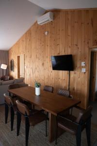 a room with a wooden wall with a table and chairs at Le 2800 du Parc in Shawinigan