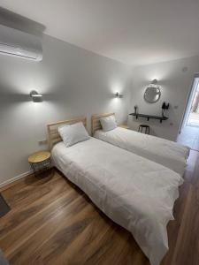 um quarto com 2 camas e lençóis brancos em Мотел Тихия кът em Sófia