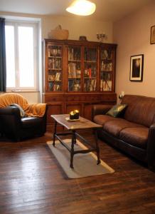 uma sala de estar com um sofá e uma mesa de centro em Gîte du Chat noir (Brocéliande) em Campénéac