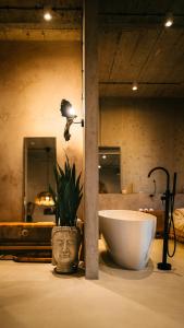 een badkamer met een bad en een plant in een vaas bij Tulum Apartament - Luxury & Top Design - Bath - Spodek - Free Parking in Katowice