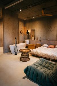 een slaapkamer met een bed en een bad en een bed en een tafel bij Tulum Apartament - Luxury & Top Design - Bath - Spodek - Free Parking in Katowice