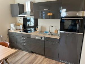 una cocina con fregadero y estufa horno superior en Ferienwohnung Burgsitz, en Spangenberg