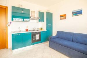 a living room with a blue couch in a kitchen at Raffaella 2 in Campese