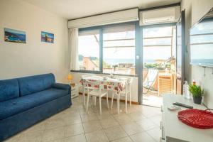 a living room with a blue couch and a table at Raffaella 2 in Campese