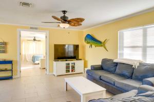 een woonkamer met een blauwe bank en een flatscreen-tv bij Big Pine Key Home on Bogie Channel with Dock and Slip! in Big Pine Key