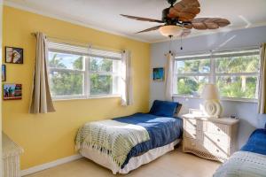 a bedroom with a bed and two windows at Big Pine Key Home on Bogie Channel with Dock and Slip! in Big Pine Key