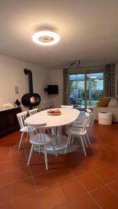 - une table et des chaises blanches dans le salon dans l'établissement Garden Suite, à Bolzano