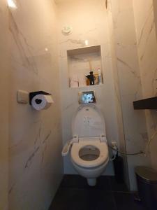 a small bathroom with a white toilet in a room at Appartement met 2 slaapkamers en tuin in Amsterdam in Amsterdam
