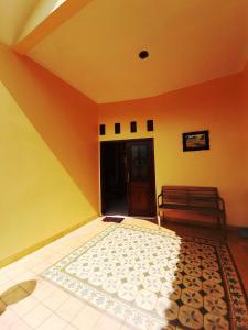 a room with an orange and yellow wall with a rug at Serasa Rumah Couple in Yogyakarta