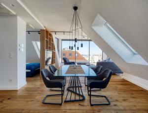 uma sala de jantar com uma mesa de vidro e cadeiras em Nook Zehn Apartments & Loft by Irundo em Viena