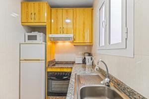 Una cocina con fregadero y refrigerador blanco. en Sunflower Costa Blanca, en Santa Pola 12 fotos más