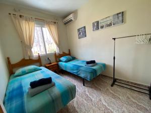 a bedroom with two beds and a window at Casa Pelican in Orihuela Costa +19 photos