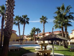 a view of a resort with palm trees and a fountain at Casa Pelican in Orihuela Costa