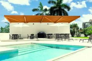 a pool with chairs and umbrellas and a grill at Maho: Cozy Studio with pool&gym in Maho Reef