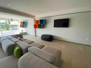 a living room with a couch and a flat screen tv at Maho: Cozy Studio with pool&gym in Maho Reef