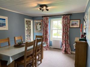 a dining room with a table and a window at Alltcreich in Craignure