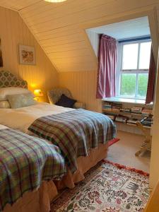 a bedroom with two beds and a window at Alltcreich in Craignure