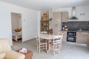 uma cozinha e sala de estar com mesa e cadeiras em La Luberonnette em Saint-Saturnin-dʼApt