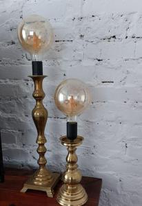 two lamps sitting on a table next to a wall at Apartament z Napoleonem w tle in Lidzbark Warmiński