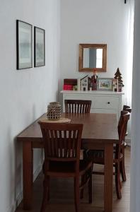 a dining room table with chairs and a mirror at Apartament z Napoleonem w tle in Lidzbark Warmiński