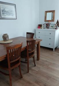 a dining room table with two chairs and a dresser at Apartament z Napoleonem w tle in Lidzbark Warmiński